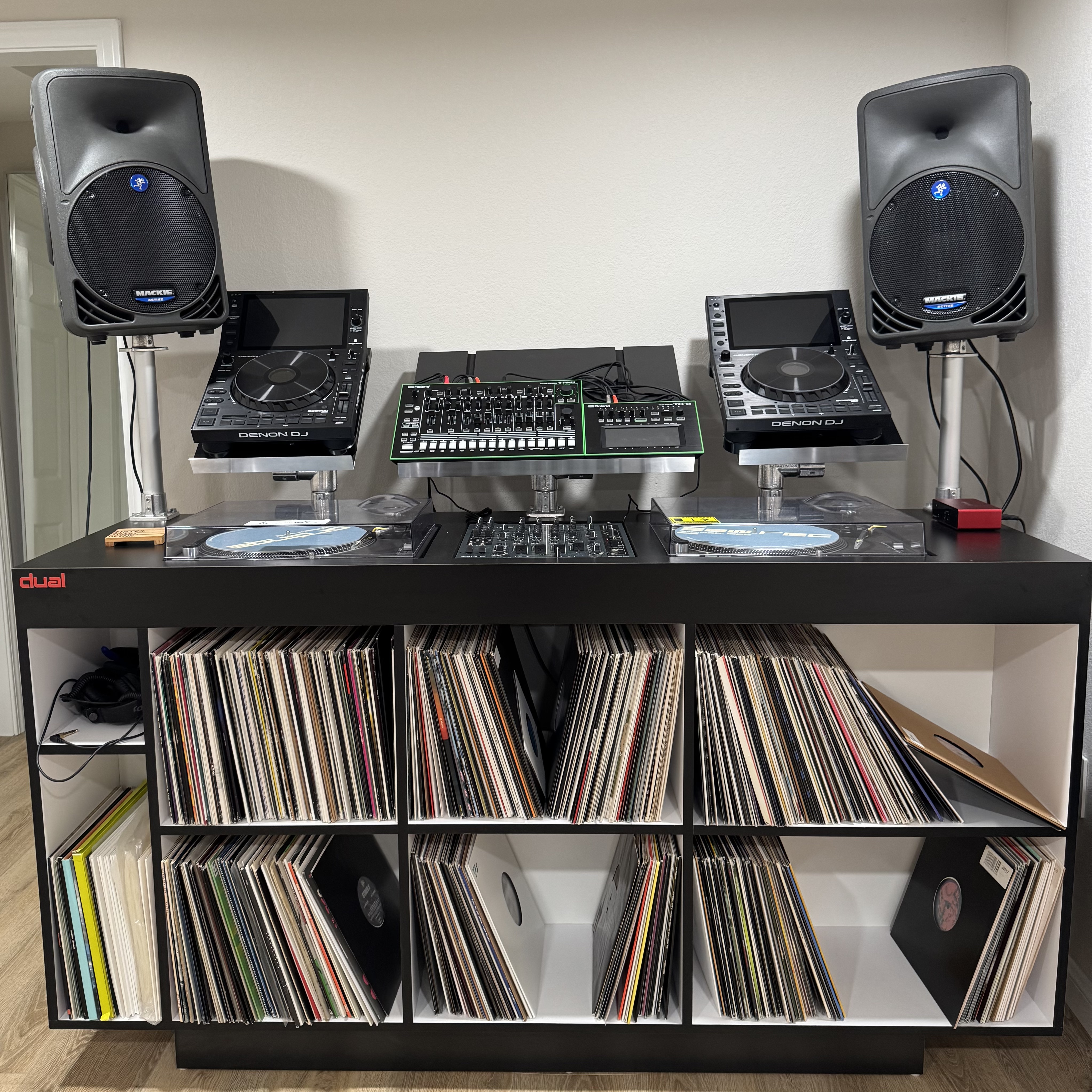 DJ booth with turntables, mixer, and vinyl records